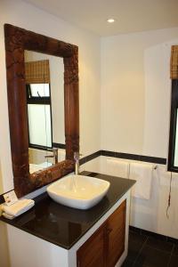 a bathroom with a sink and a mirror at Kamala Beach Estate Apartment - SHA PLUS in Kamala Beach