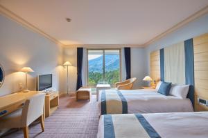 Cette chambre comprend deux lits et un bureau. dans l'établissement L'Hotel de Hiei, à Kyoto