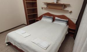 ein Schlafzimmer mit einem Bett mit weißen Laken und Kissen in der Unterkunft Уютен апартамент в Търговище - 2 спални и кухня in Targowischte