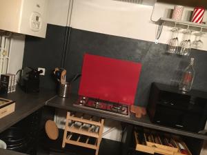 a kitchen with a stove with a red board on it at La Pénates in Château-Regnault-Bogny