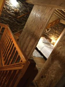 an attic with a bed and a wooden staircase at La Pénates in Château-Regnault-Bogny