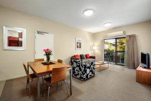 uma sala de estar com uma mesa e um sofá em Gladstone Downtown Central Apartment Hotel Official em Gladstone