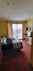 sypialnia z łóżkiem i dużym oknem w obiekcie Apart Hotel Uman w mieście Concepción