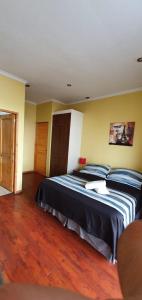 a bedroom with a bed with blue pillows on it at Apart Hotel Uman in Concepción