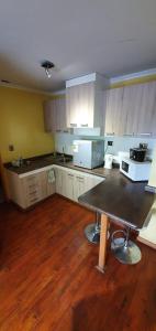 a kitchen with a table in the middle of it at Apart Hotel Uman in Concepción