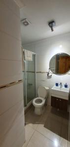 y baño con aseo, lavabo y ducha. en Apart Hotel Uman en Concepción