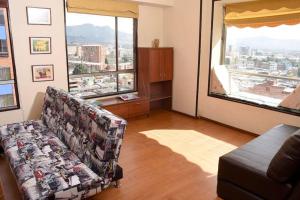 ein Wohnzimmer mit einem Sofa und einem großen Fenster in der Unterkunft HOMY APARTAMENTOS #7 - Corferias, embassy, airport, G12, UN, Agora in Bogotá
