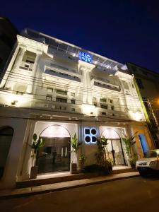 HOOD Hostel في يانغون: مبنى أبيض مع واجهة مضاءة في الليل