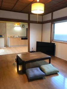 a living room with a table and a kitchen at 蒼 aoi in Shingū