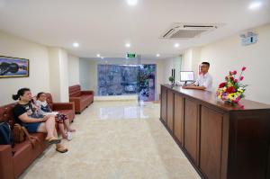 Ein Mann steht an einer Theke in einer Krankenhauslobby. in der Unterkunft Harvey Hotel & Apartments in Nha Trang