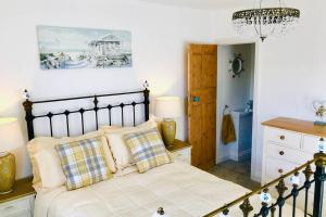 a bedroom with a bed and a chandelier at Seascape Cottage, Ventnor in Ventnor