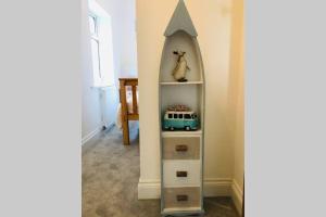 a shelf with a mirror in the corner of a room at Seascape Cottage, Ventnor in Ventnor