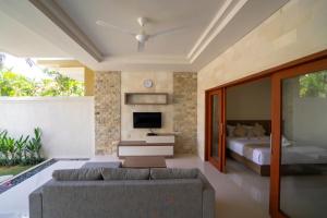 a living room with a bed and a couch at Juada Garden in Seminyak