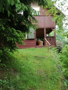 una casa roja con un patio delante en Robakówka, en Ochotnica Dolna