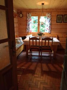 a dining room with a table and chairs in a cabin at Robakówka in Ochotnica Dolna +24 photos