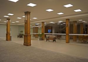 a large room with wooden columns and tables and chairs at Sky Palace Hotel in Gramado