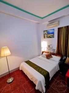 a bedroom with a large white bed and a lamp at Yilan Golf B&B in Wujie