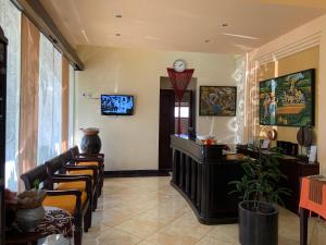 a waiting room with chairs and a clock on the wall at Nirwana Suites in Denpasar