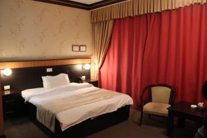Un pat sau paturi într-o cameră la Alp Inn Hotel