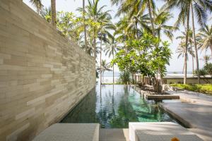 a swimming pool in a resort with palm trees at Kelapa Retreat & Spa in Pulukan +37 photos