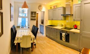 a kitchen with a table and a dining room at Seascape Cottage, Ventnor in Ventnor
