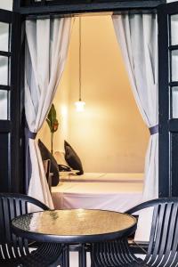 a table and chairs in a room with a window at The Marian Boutique Lodging House in Kuching