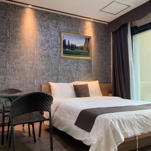 a bedroom with a bed and a table and chairs at CS Premier Hotel in Anyang