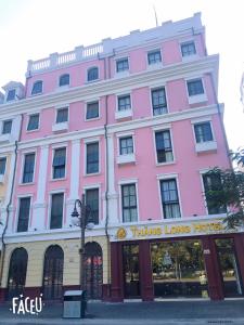 ein rosafarbenes Gebäude mit einem denken langen Hotel in der Unterkunft Thăng Long Hotel II in Hạ Long