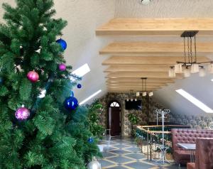 a christmas tree in the lobby of a restaurant at Мотel VEZHA 363kmE40 in Molodava