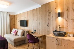 ein Hotelzimmer mit einem Waschbecken und einem Sofa in der Unterkunft Boutiquehotel die Alpbacherin 4 Sterne Superior in Alpbach