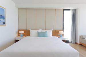 A bed or beds in a room at TMS Hotel Da Nang Beach