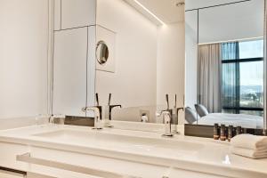 a bathroom with a sink and a mirror at COOL MAMA Hotel Salzburg in Salzburg