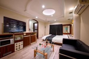 um quarto de hotel com uma cama e uma televisão em HOTEL MOBILIA (Adult Only) em Tsurugashima