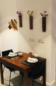 uma mesa de madeira com cadeiras, pratos e vasos na parede em Studio 116 - Ebene Square em Ebene