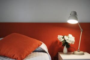 a bedroom with a bed and a lamp and flowers at Oasi Di Cavoretto in Turin