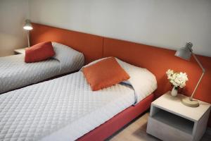 een slaapkamer met 2 bedden met een oranje hoofdeinde bij Oasi Di Cavoretto in Turijn
