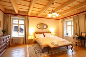 a bedroom with a bed and a table and windows at Lucerna - dům s duší Příbor in Příbor