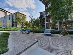 a courtyard with benches and chairs in front of a building at Baan S.W.A.T by 23 Degree Khao Yai in Ban Huai Sok Noi