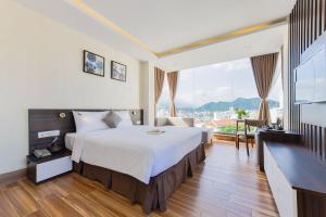 a hotel room with a large bed and a large window at Yen Vang Hotel & Apartment Nha Trang in Nha Trang