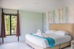 una camera con letto e finestra di Mae On Village Resort a Roi Et