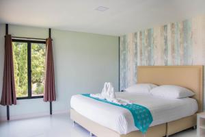 a bedroom with a bed and a window at Mae On Village Resort in Roi Et