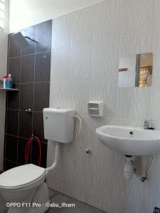 a bathroom with a toilet and a sink at Ilham Imani Homestay in Kampung Gurun