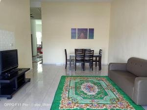 a living room with a couch and a table and chairs at Ilham Imani Homestay in Kampung Gurun