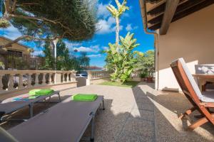 a patio with a table and chairs and trees at Alga Marina in Son Serra de Marina