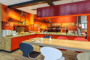 
a kitchen with a table and chairs in it at ibis Hotel Erfurt Altstadt in Erfurt
