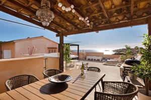Une table et des chaises en bois sont disponibles sur la terrasse. dans l'établissement Villa Can Moya, à Palma de Majorque
