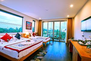 um quarto de hotel com duas camas e uma grande janela em Silk and Sea Hotel em Hoi An