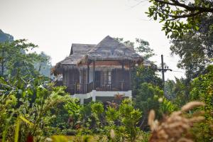 uma casa com varanda no meio de uma floresta em Wareerak Hot Spring & Wellness- SHA Extra Plus em Khlong Thom