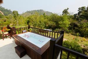 bañera de hidromasaje en la cubierta de una casa en Wareerak Hot Spring & Wellness- SHA Extra Plus, en Khlong Thom