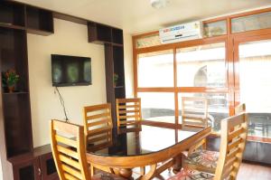 comedor con mesa, sillas y TV en Shivaganga Houseboat- VACCINATED STAFF, en Kumarakom